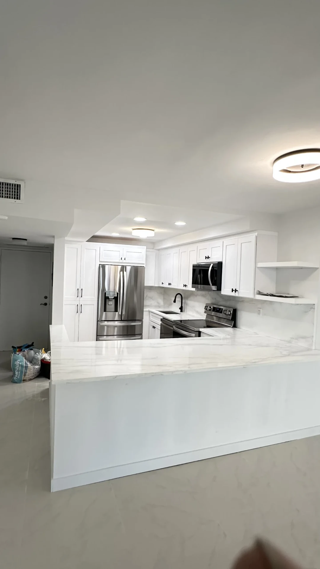 Finished kitchen with white cabinets and marble island