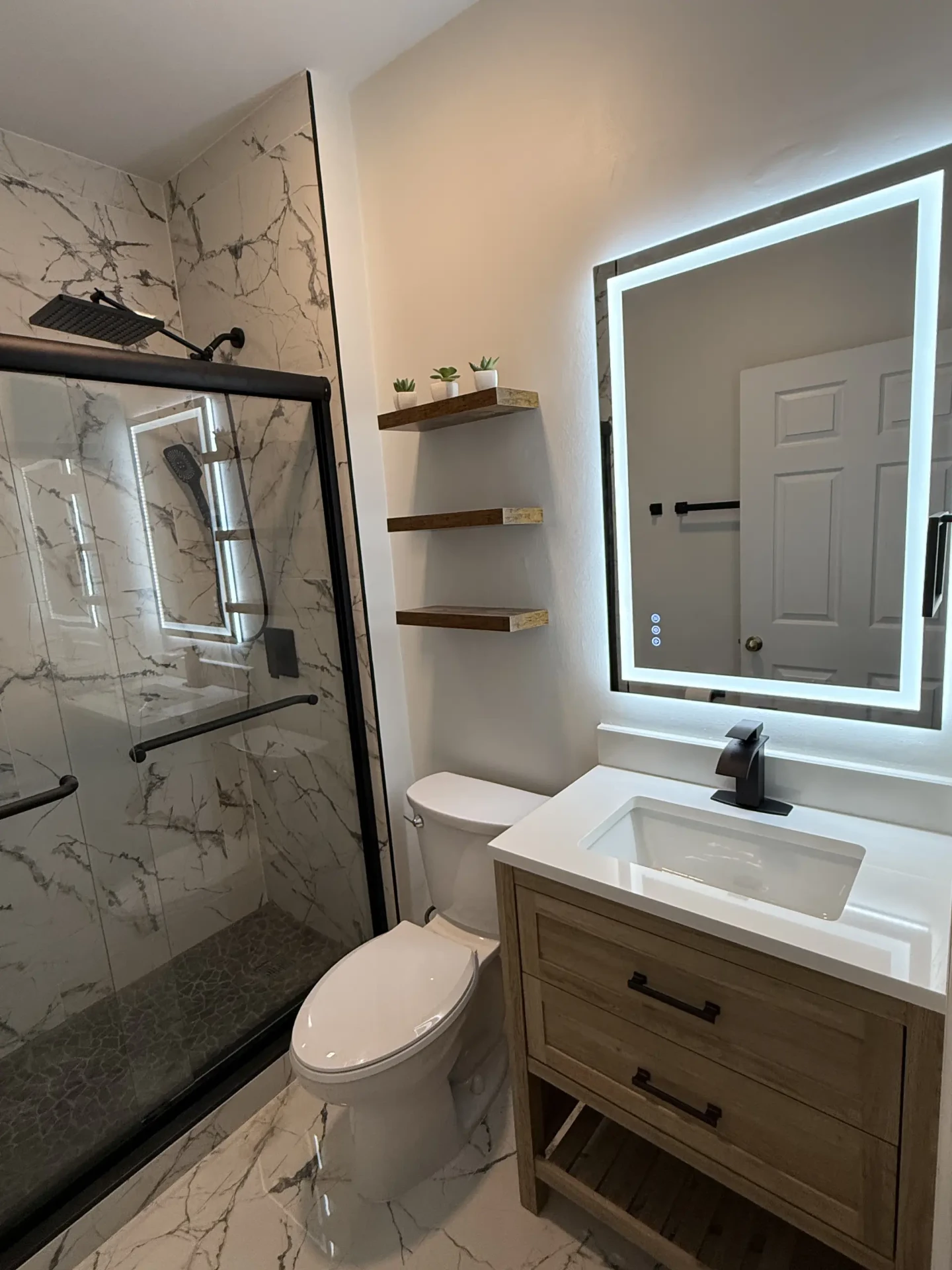 Finished bathroom with tiled shower and modern vanity